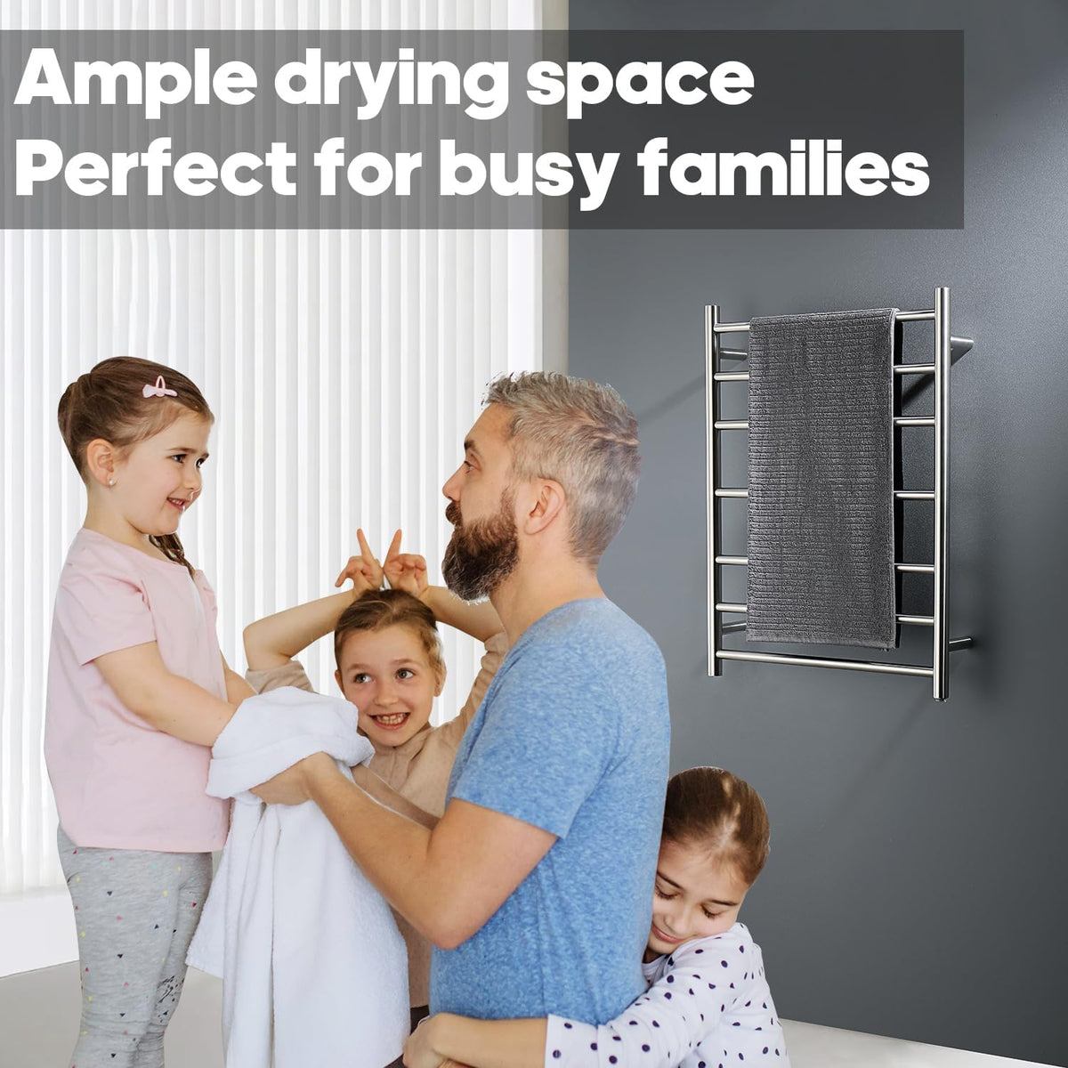 A family scene in a bathroom with a man drying two children on a white towel while a girl sits beside him. A wall-mounted chrome towel rack with a dark gray towel is visible on the right, with the text 'Ample drying space Perfect for busy families' at the top. Decaura 7-Bar Heated Towel Rail